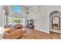 Bright living room with two-story ceiling, hardwood flooring, and large windows overlooking the yard at 6857 Eagle Ridge Loop, Lakeland, FL 33813