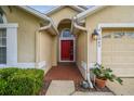 Close-up of a red front door with brick entryway, side lights, and manicured landscaping at 1045 View Pointe Way, Lakeland, FL 33813