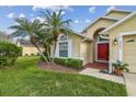 Exterior shot of the house featuring a red front door, landscaping, and an attached two-car garage at 1045 View Pointe Way, Lakeland, FL 33813