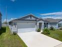 Beautiful one story home with manicured lawn and a two car garage on a sunny day at 1029 Mattie Pointe Way, Auburndale, FL 33823