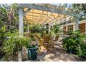 Outdoor patio area with pergola, stone flooring, and yellow chairs at 7525 Catherine Dr, Lakeland, FL 33810