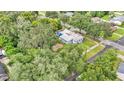 Aerial view of home featuring ample yard space, lush trees, and a shimmering blue pool at 1705 Davis Ave, Bartow, FL 33830