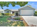 Charming single-story home featuring well-manicured landscaping and an attached two-car garage at 511 Alcazar Ct, The Villages, FL 32159