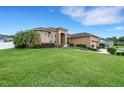Expansive front lawn of a home with palm trees, fresh green grass, and a neatly kept, landscaped yard at 5074 Shore Side Dr, Lakeland, FL 33812