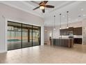 Open-concept kitchen featuring dark wood cabinets, pendant lighting, island, and direct view of the pool at 5074 Shore Side Dr, Lakeland, FL 33812