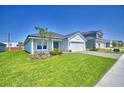 A well-kept lawn accents this single-story home with a two-car garage in a modern neighborhood at 4682 Grandview Glen Dr, Auburndale, FL 33823