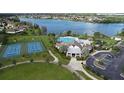Aerial view of a community center with a pool, tennis courts, parking, and access to a scenic lake at 5514 Maggiore Blvd, Lakeland, FL 33805