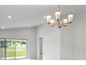 Bright dining room features a modern chandelier and sliding glass doors to backyard at 559 Sw 77Th Cir, Ocala, FL 34474