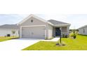 Inviting single Gathering home with a well-kept lawn, front door, and two car garage at 559 Sw 77Th Cir, Ocala, FL 34474