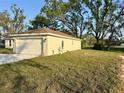 Side view of the house with a two-car garage and green lawn at 1271 Groveland Ln, Lakeland, FL 33811