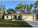 Charming single-story home with a well-maintained lawn and a two-car garage at 1271 Groveland Ln, Lakeland, FL 33811