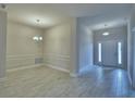 Spacious entryway showcasing wood-look tile flooring and a formal dining area to the left at 4688 Grandview Glen Dr, Auburndale, FL 33823