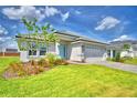 Beautiful single-story home featuring a well-maintained lawn and a light blue front door at 4688 Grandview Glen Dr, Auburndale, FL 33823