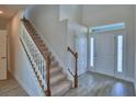 Bright foyer featuring wood-look tile flooring, staircase, and a front door with sidelight at 4694 Grandview Glen Dr, Auburndale, FL 33823