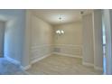 Formal dining area with wainscoting, neutral paint, and modern light fixture at 4700 Grandview Glen Dr, Auburndale, FL 33823