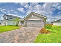 Beautiful home exterior with a manicured lawn, brick driveway, and inviting entrance at 4706 Grandview Glen Dr, Auburndale, FL 33823