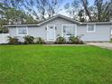 Inviting single-story home featuring fresh landscaping, a manicured lawn, and a newly painted exterior at 5225 Golden Gate Blvd, Polk City, FL 33868