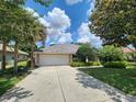 A well-maintained home featuring a tile roof, two-car garage, and meticulously manicured front lawn at 108 Lake Region N Blvd, Winter Haven, FL 33881
