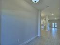 Bright hallway with neutral walls and tile flooring, leading to an open floor plan at 5126 Villa Crest Way, Auburndale, FL 33823