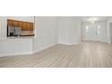 Bright living room featuring wood-look floors that lead to kitchen and front door at 1365 Melrose St, Lake Alfred, FL 33850