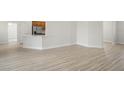 Open living room featuring stylish flooring that leads to kitchen and doorway at 1365 Melrose St, Lake Alfred, FL 33850
