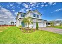 Stunning two-story house with a three-car garage, lush green lawn, vibrant landscaping, and modern architecture at 4712 Grandview Glen Dr, Auburndale, FL 33823
