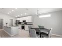 Modern kitchen with white cabinets, stainless steel appliances, granite countertops, and an adjacent dining area at 5335 Se 127Th Ln, Belleview, FL 34420