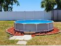An above-ground pool surrounded by red mulch, set against a white fence backdrop at 3136 Country Club Cir, Winter Haven, FL 33881