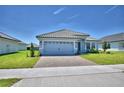 Single-story home with well-kept lawn, brick driveway, and gray exterior at 4639 Grandview Glen Dr, Auburndale, FL 33823
