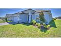 Charming single-story home with landscaped front yard, gray siding and brick driveway at 4639 Grandview Glen Dr, Auburndale, FL 33823