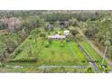 Overhead view of sprawling property with a home, pond, outbuildings, and wooded surroundings at 9240 Moore Rd, Lakeland, FL 33809