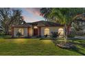 House exterior at dusk with a well-manicured lawn at 1555 Archers Path, Lakeland, FL 33809