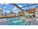 Sparkling in-ground screened pool with a lounge chair and covered seating area perfect for outdoor relaxation at 7525 Jessamine Dr, Lakeland, FL 33810