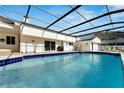 Inviting in-ground pool enclosed by a screened lanai, offering a refreshing escape in a private setting at 1323 Valley E Hl, Lakeland, FL 33813