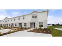 Attractive townhome featuring landscaped front yard, sidewalk, and a nearby playground at 305 Wharf Way, Winter Haven, FL 33881