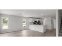 Bright living area featuring modern wood floors and two windows illuminating an open space at 305 Wharf Way, Winter Haven, FL 33881