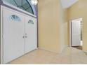 Bright foyer featuring double entry doors, neutral tile flooring, and plenty of space at 3845 Garnet Dr, Mulberry, FL 33860