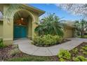 Inviting front entrance featuring turquoise double doors and lush landscaping at 3845 Garnet Dr, Mulberry, FL 33860