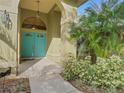 Welcoming front entrance featuring turquoise double doors and manicured landscaping at 3845 Garnet Dr, Mulberry, FL 33860