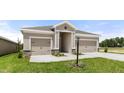 A charming home featuring a welcoming entrance, attached two-car garage, and well-maintained landscaping at 715 Sw 77Th Cir, Ocala, FL 34474