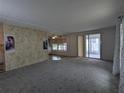 Bright living room featuring neutral carpet, an accent wall, and sliding glass doors to the sunroom at 1610 Reynolds Rd # 211, Lakeland, FL 33801