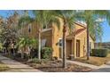 Inviting two-story townhome with a red tiled roof, surrounded by palm trees and lush landscaping at 531 Las Fuentes Dr, Kissimmee, FL 34746