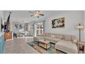 Open living room with sectional sofa, coffee table, and Mickey Mouse art at 531 Las Fuentes Dr, Kissimmee, FL 34746