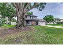 Charming two-story home featuring a well-manicured lawn, light gray paint, brick accents, and a driveway leading to a two-car garage at 1305 Avenue S Nw, Winter Haven, FL 33881
