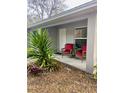 Covered porch with two red chairs and potted plants at 520 Green Cir, Fort Meade, FL 33841