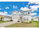 Two-story house with gray siding, two-car garage, and landscaped yard at 5460 Siltstone St, Lakeland, FL 33811