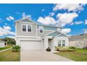 Two-story house with gray siding, two-car garage, and landscaped yard at 5460 Siltstone St, Lakeland, FL 33811