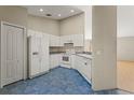 Well-lit kitchen with white cabinets, standard appliances, and blue tile flooring at 8183 Westmont Terrace Dr, Lakeland, FL 33810