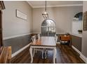 Charming dining room with hardwood floors, a wood table, and an arched window at 111 Arbor Way, Auburndale, FL 33823