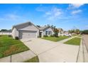 Wonderful neighborhood view showcasing a light gray home with a two-car garage at 1655 Laurel Oaks Dr, Bartow, FL 33830